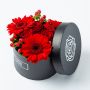 Rood bloemstuk in zwart hoedendoosje bovenaf