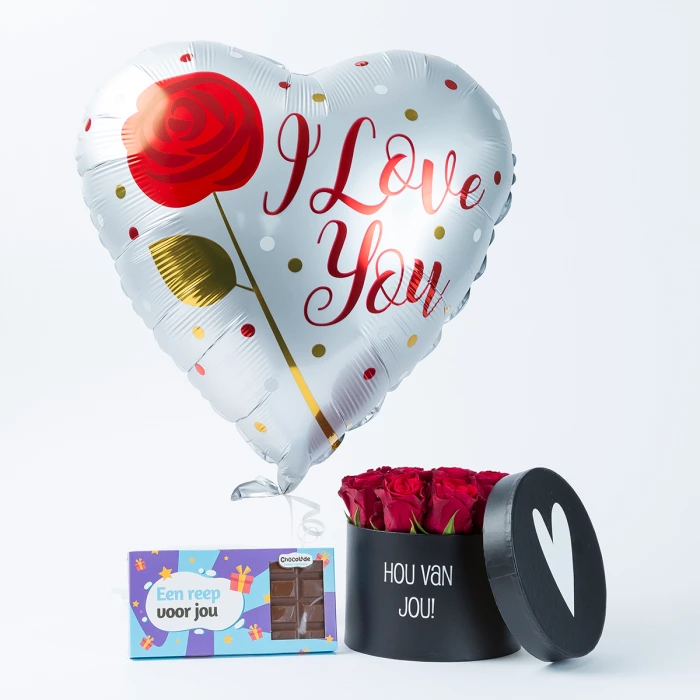 Ronde, zwarte doos met een wit hart erop en de tekst "hou van jou", gevuld met roze rozen, nr 7 idee cadeaupakket vrouw
