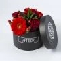 Rood bloemstuk in zwart hoedendoosje bovenaf